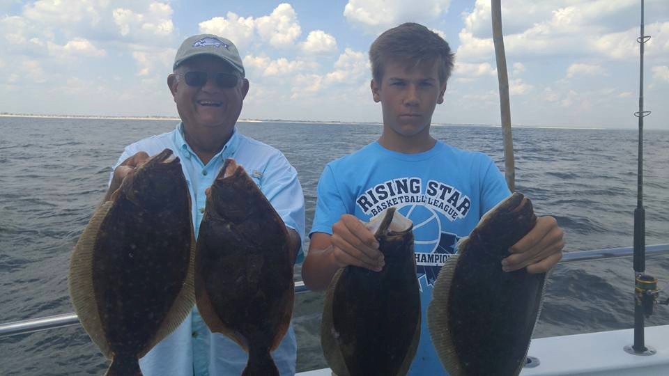 Anglers holding fluke caught on a local party boat. (Shorebeat File Photo)