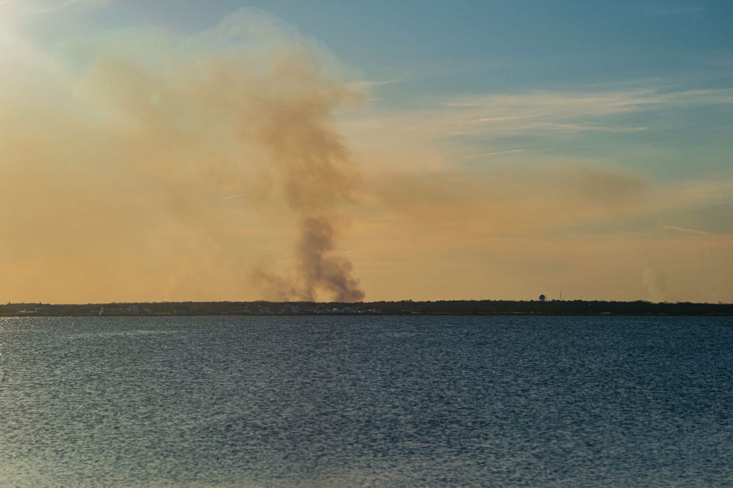A controlled burn in Ocean County, N.J. produces a plume of smoke over Barnegat Bay, Feb. 28, 2022. (Photo: Daniel Nee)