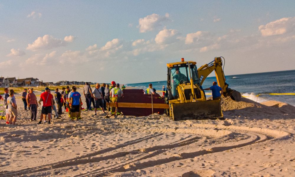 Rescue workers searching for a teen missing after a hole in the beach sand collapse, May 17, 2022. (Photo: Daniel Nee)
